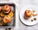 Baked red apples with granola, cinnamon, nuts and honey on stone background. Healthy fruit vegetarian dessert. Top view, flat lay